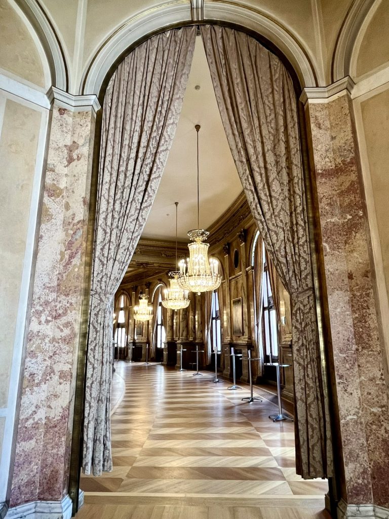 Bogen eines roten Theatervorhangs im Burgtheater